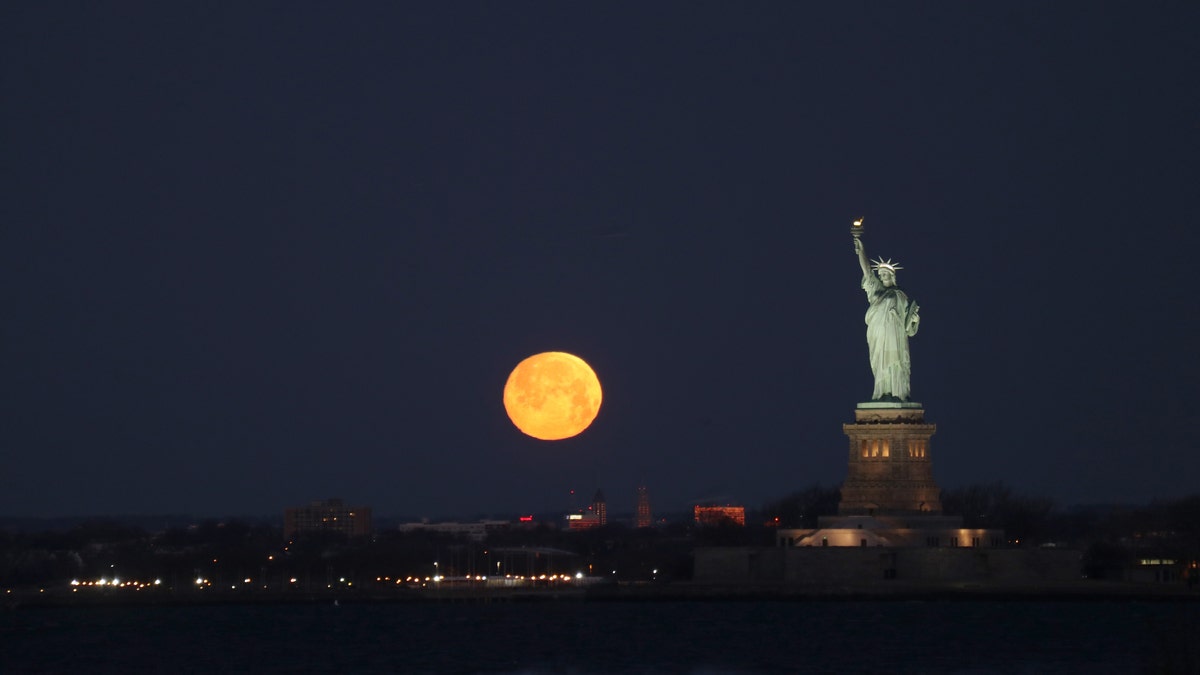 The moon sets behind the Statue of Liberty, Feb. 8, 2020.