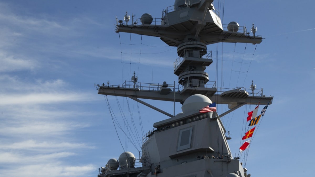 USS Gerald R. Ford (CVN 78) raises the American flag on its mast as the ship get underway,.