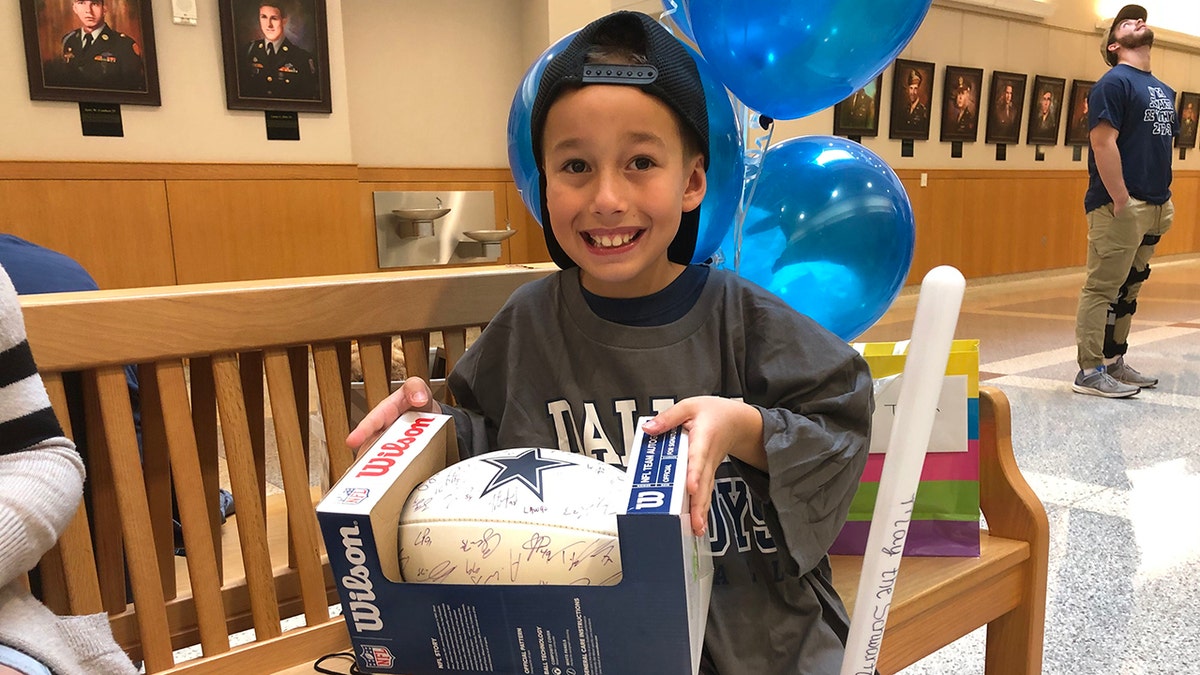 Nike got a huge surprise when he was gifted with a football signed by his favorite NFL player, Cowboys quarterback Dak Prescott and the entire 2019 Cowboys team. (Photo: Courtesy of Buckner International)