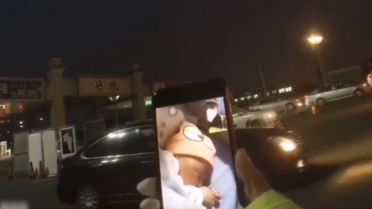 Officer Zhang Lin is patrolling a traffic checkpoint amid the coronavirus outbreak and missed the birth of his child, who he later met via video chat. 