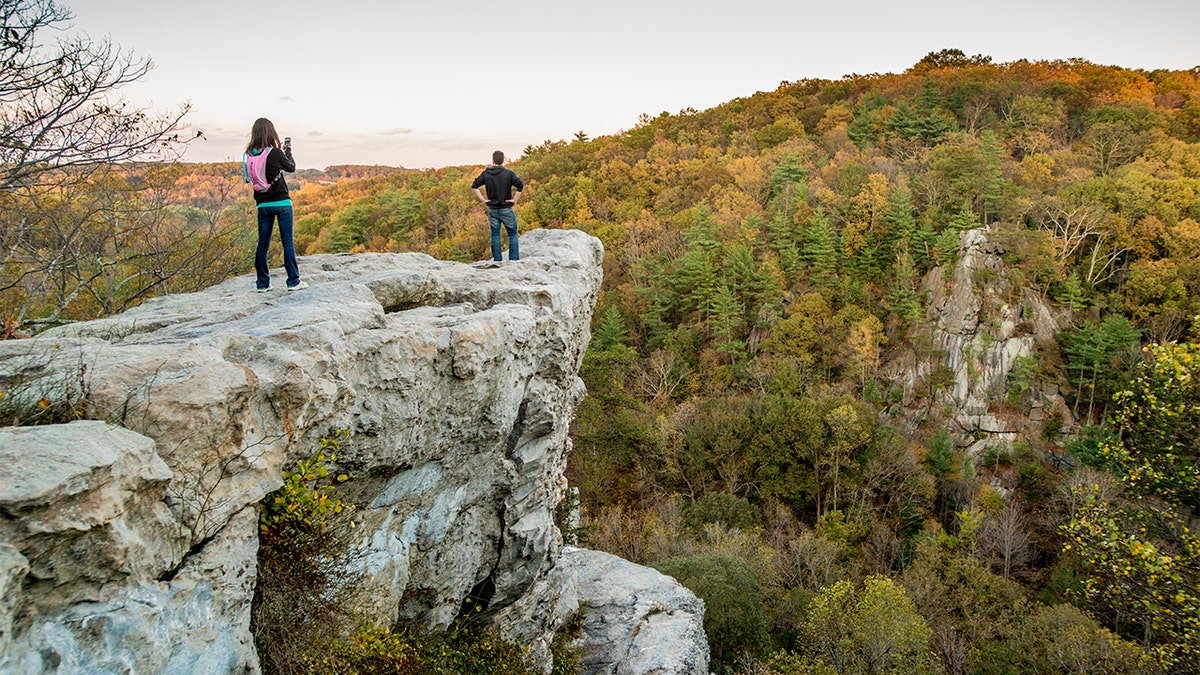 A man and woman on the King and Queen Seat rock formation at Rocks State Park in Maryland. (Edwin Remsburg/VW Pics via Getty Images, File)