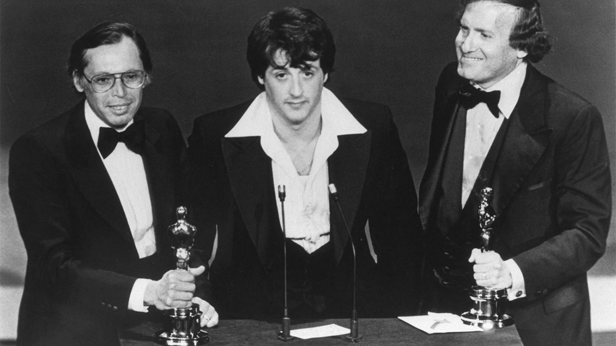 Sylvester Stallone, with producers Irwin Winkler (L), and Robert Chartoff (R), receive the Best Picture award for their movie Rocky during the 49th Academy Awards ceremony. (Photo by Axel Koester/Sygma via Getty Images)