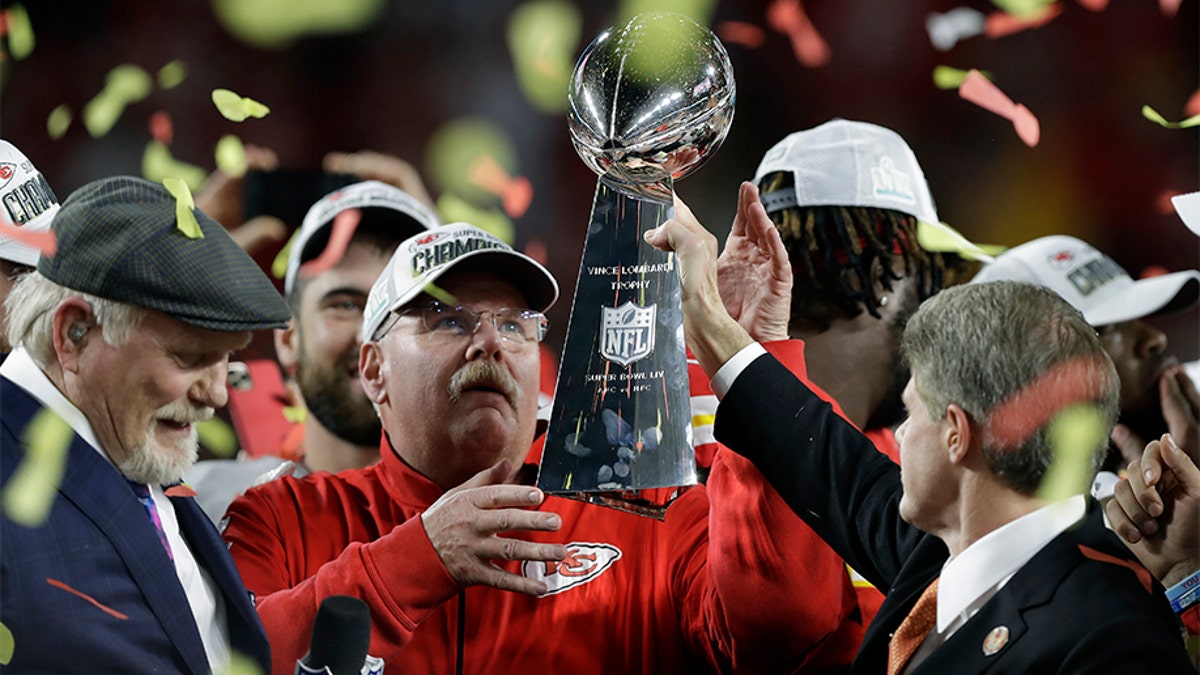 Kansas City Chiefs chairman Clark Hunt, right, hands the trophy to head coach Andy Reid after the Chiefs defeated the San Francisco 49ers in the NFL Super Bowl 54. (AP Photo/Chris O'Meara)