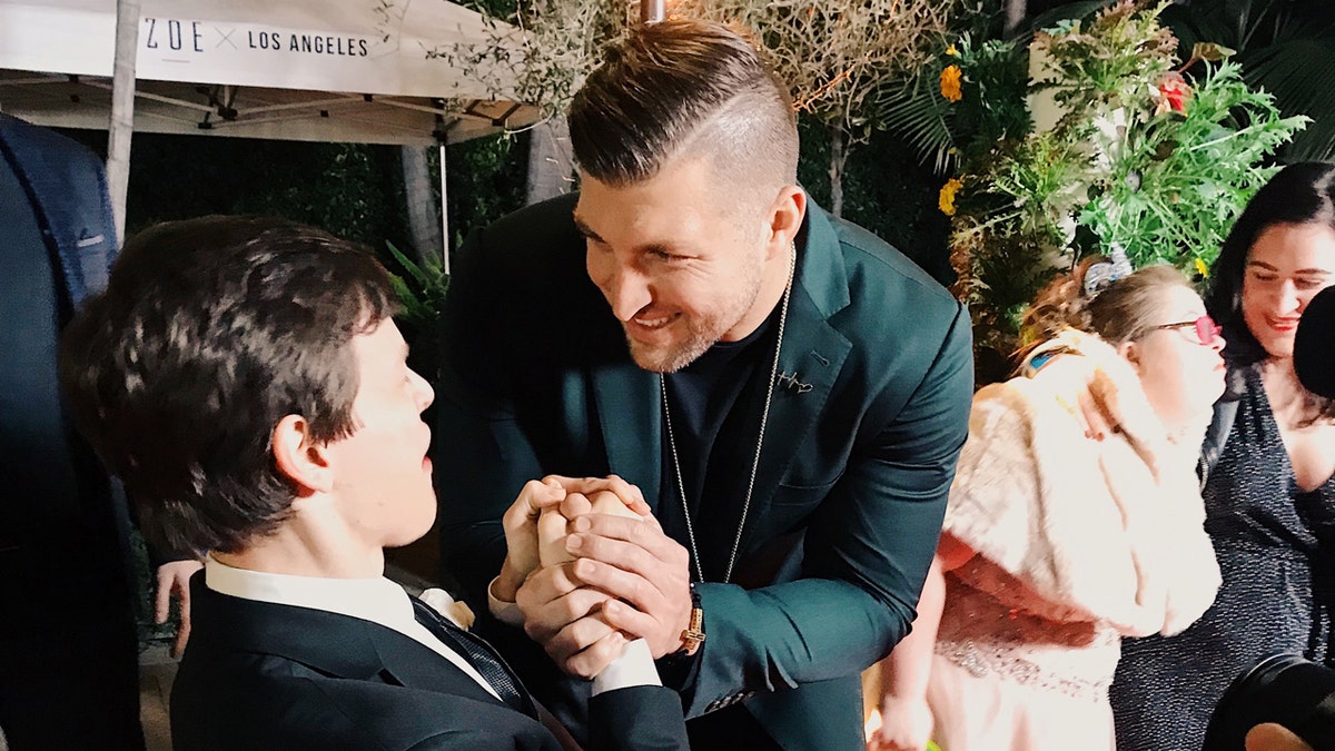 Micah Fowler meeting Tim Tebow on the red carpet at Zoe Church’s Night to Shine in 2019.