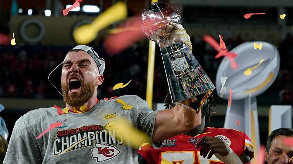 Kansas City Chiefs' Travis Kelce hoists the trophy after defeating the San Francisco 49ers in the NFL Super Bowl 54 football game Sunday, Feb. 2, 2020, in Miami Gardens, Fla. (AP Photo/David J. Phillip)