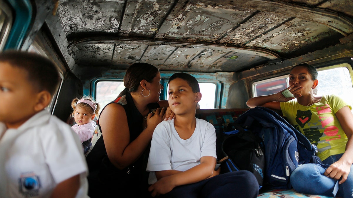 Passengers ride on public transport in Caracas, Venezuela on Wednesday. Families have been split up with at least 4.5 million Venezuelans fleeing crumbling public services. (AP Photo/Ariana Cubillos)