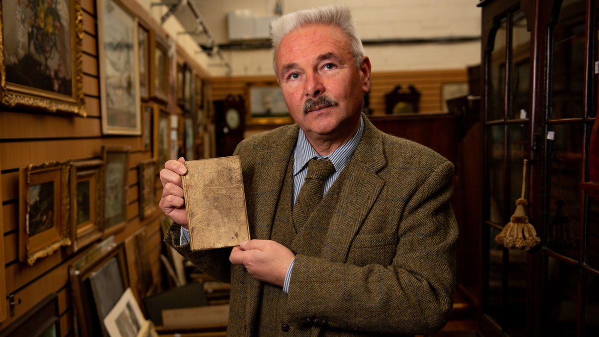 Militaria expert Adrian Stevenson of Hansons Auctioneers holds the diary written by British World War I soldier Arthur Edward Diggens.