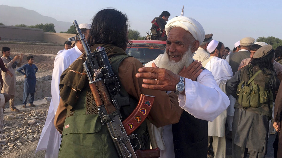 In this June 16, 2018 file photo, Taliban fighters gather with residents to celebrate a three-day cease fire marking the Islamic holiday of Eid al-Fitr, in Nangarhar province, east of Kabul, Afghanistan. (AP Photo/Rahmat Gul, File)