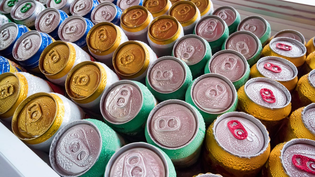 Beer cans Fresh from the fridge. Lots of aluminum cans in the ice in the open fridge. Drops of water on a cold can of drink