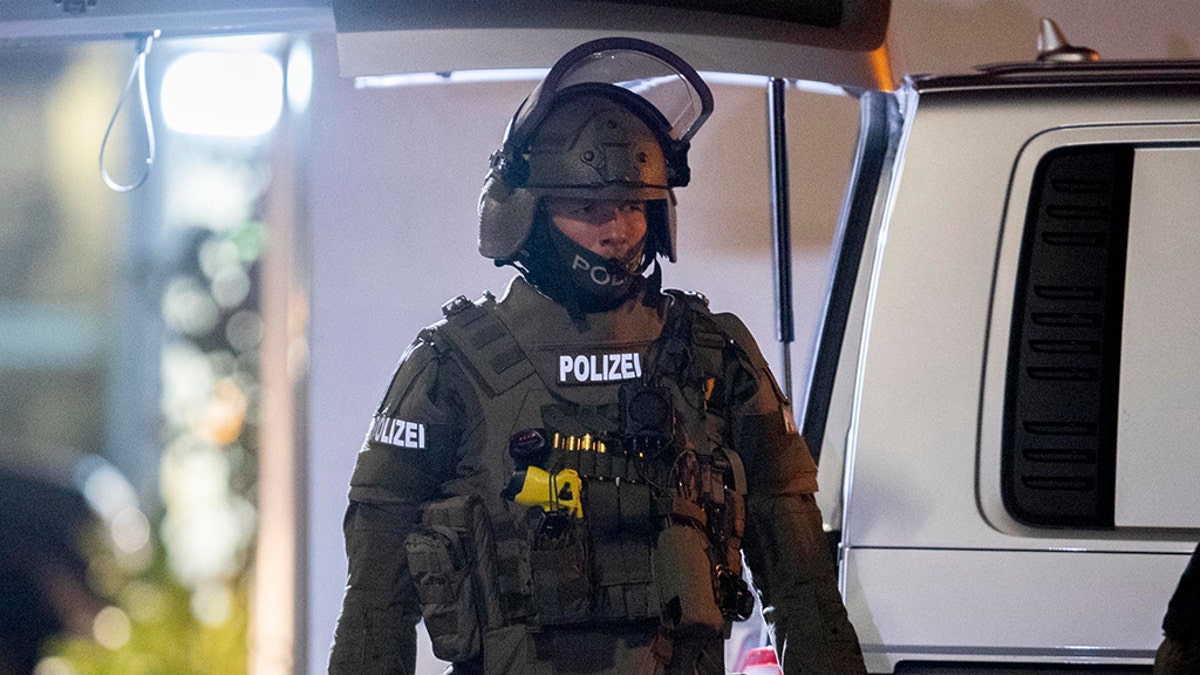 A special forces officer guards the road in front of a house that is searched through by police in Hanau, Germany, Thursday, Feb. 20, 2020. (Associated Press)