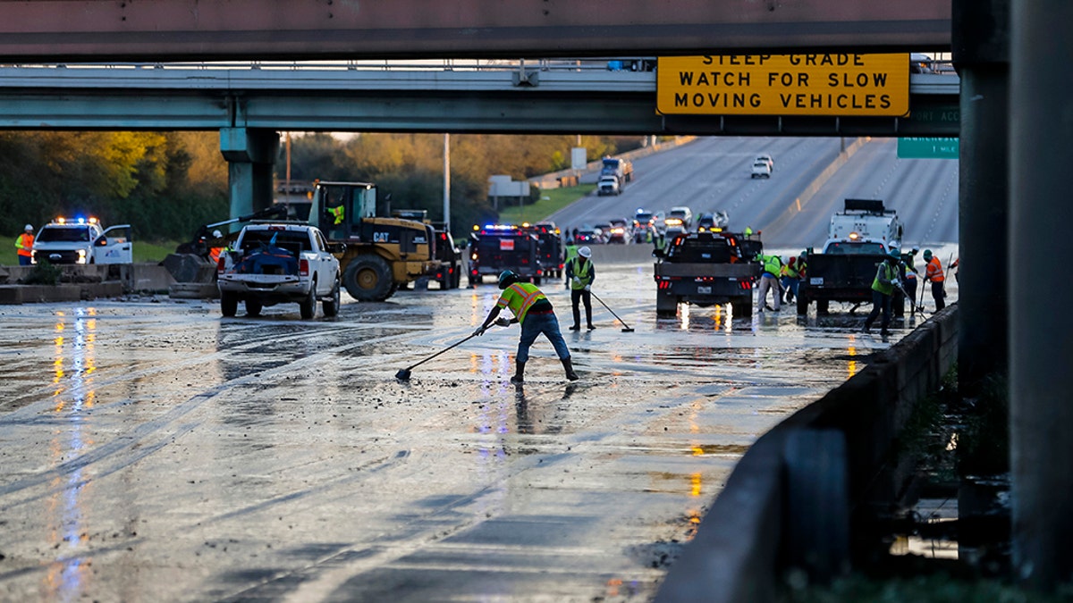 Workers clean water from the southbound lanes of 610 at Clinton Drive, Thursday, Feb. 27, 2020, in Houston. (Associated Press)