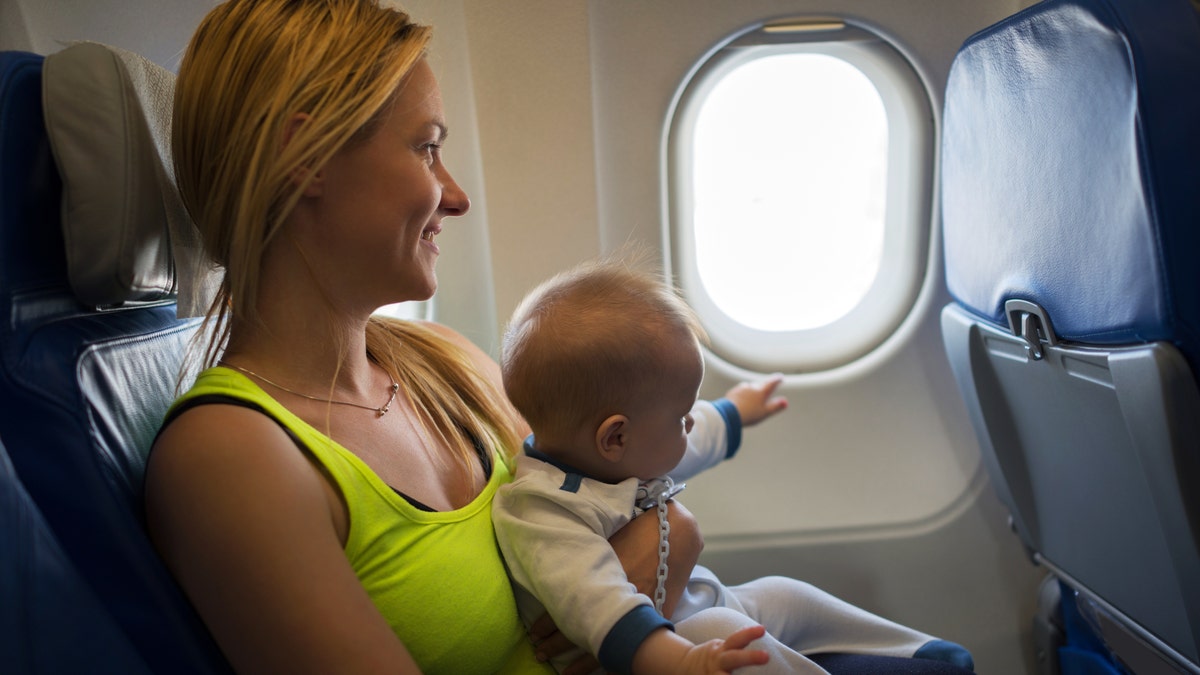 Mother holds baby on plane