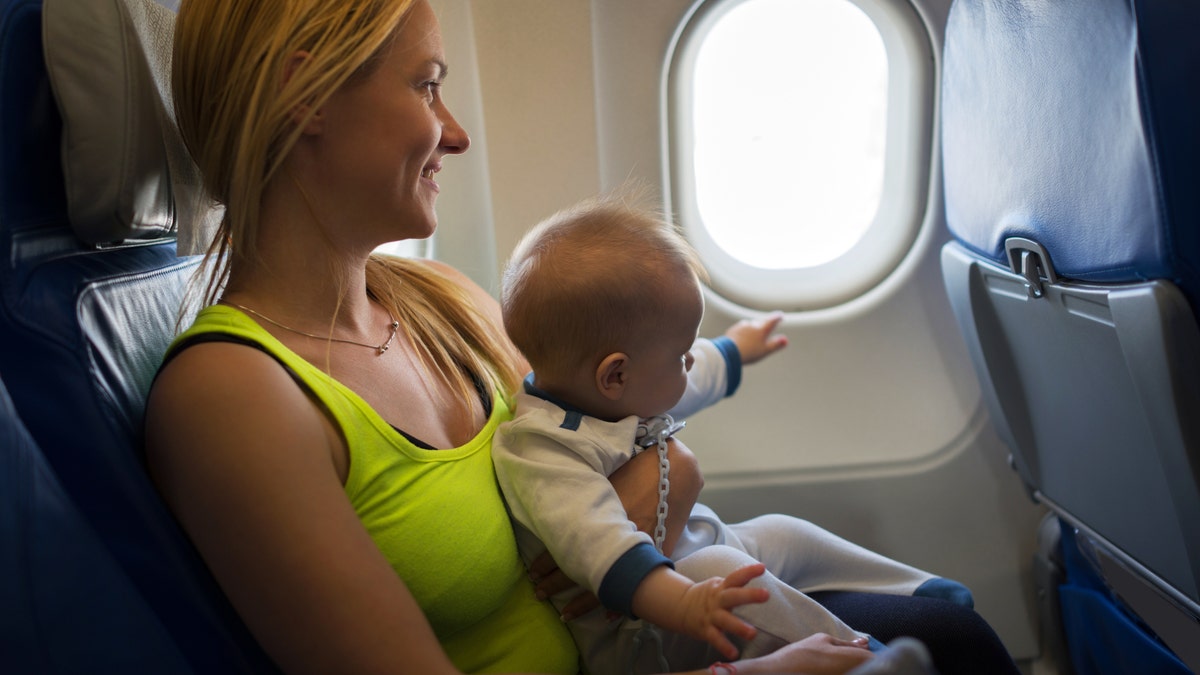 Mother holds baby on plane