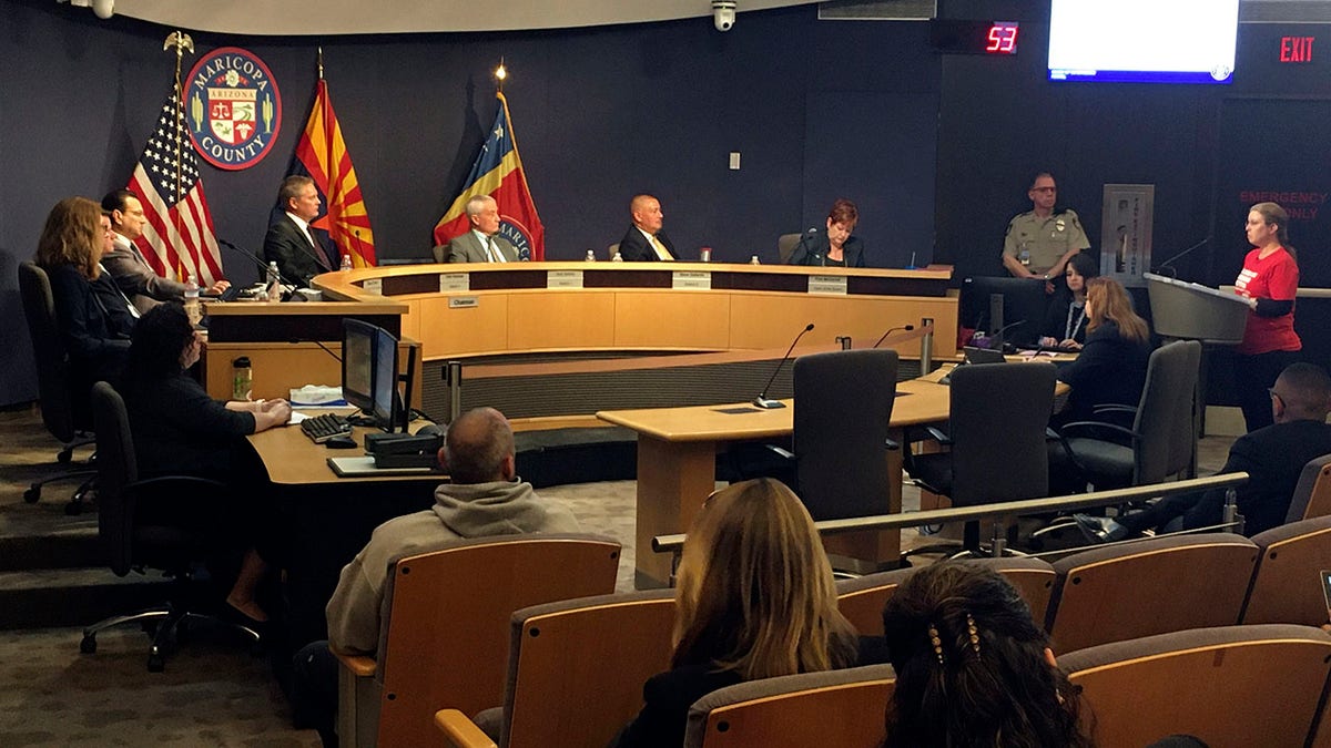 The Maricopa County Board of Supervisors listens to comments from Marie Thearle, right, a gun control supporter, during a meeting in Phoenix on Wednesday. 