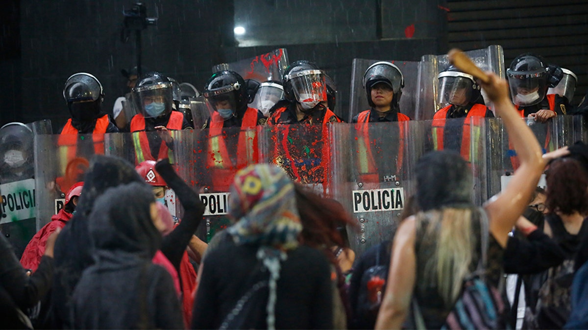 Riot police form a cordon during a demonstration by women against gender violence in Mexico City on Friday. (AP)