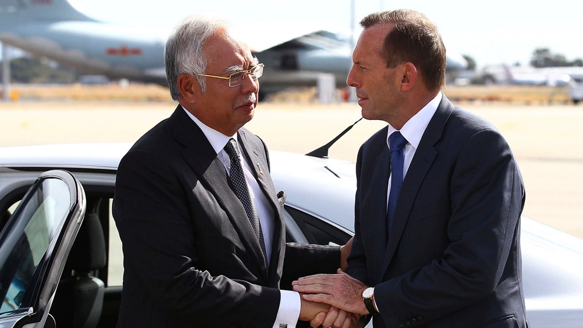 In this April 3, 2014, file photo, Australian then Prime Minister Tony Abbott, right, shakes hands with Malaysian then Prime Minister Najib Razak as Razak prepares to depart Australia after his visit during the search of the missing Malaysia Airlines flight MH370 at Perth International Airport, Australia.