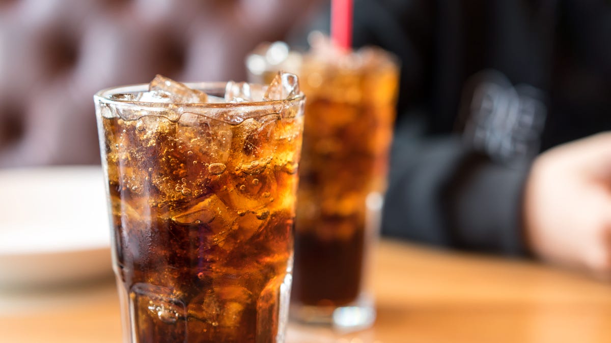 Soft drink on wooden table and men sitting