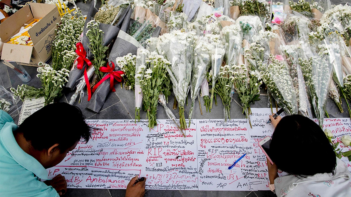 People write notes and leave flowers at the scene of the shooting. (AP)