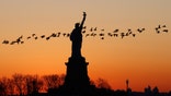 JERSEY CITY, NJ - FEBRUARY 23: Geese fly past the Statue of Liberty as the sun rises in New York City on February 23, 2020 as seen from Jersey City, New Jersey. (Photo by Gary Hershorn/Getty Images)