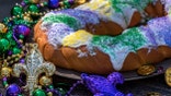 king cake surrounded by mardi gras decorations