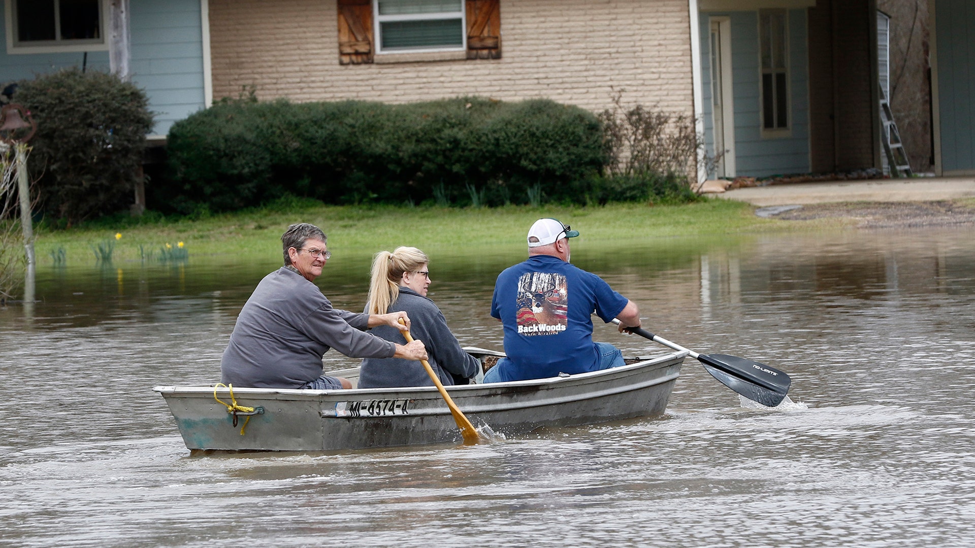 Dale Frazier and his neighbors John and Jina Smith paddle across Pearl River floodwater to their Flowood, Miss., homes Sunday, Feb. 16, 2020.