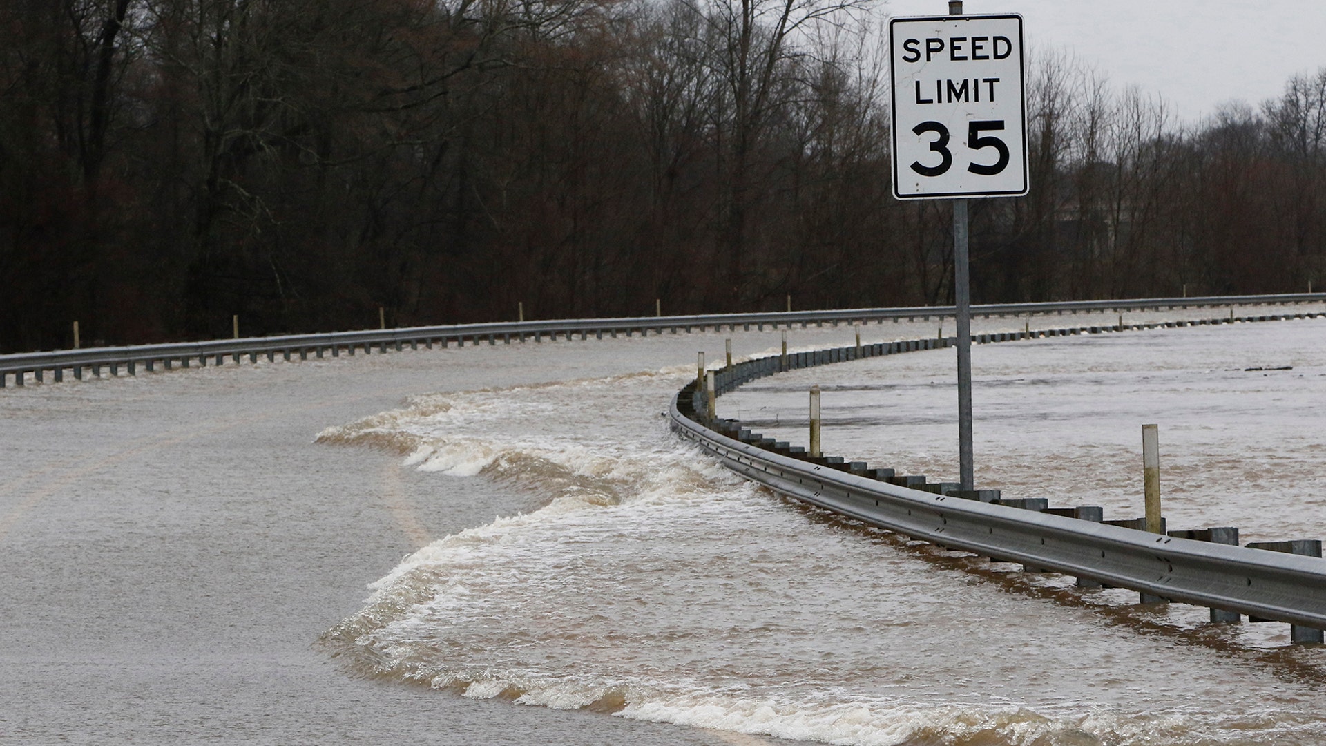 Strong currents from the swollen Pearl River flood over the Old Brandon Road Bridge in Jackson, Miss., Sunday.