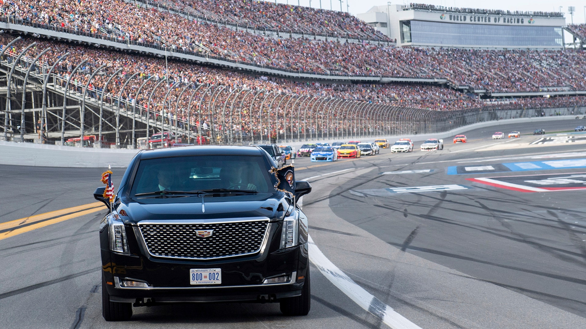 President Donald Trump and first lady Melania Trump ride in the presidential limousine as they take a pace lap ahead of the start of the NASCAR Daytona 500 auto race at Daytona International Speedway, Feb. 16, 2020.