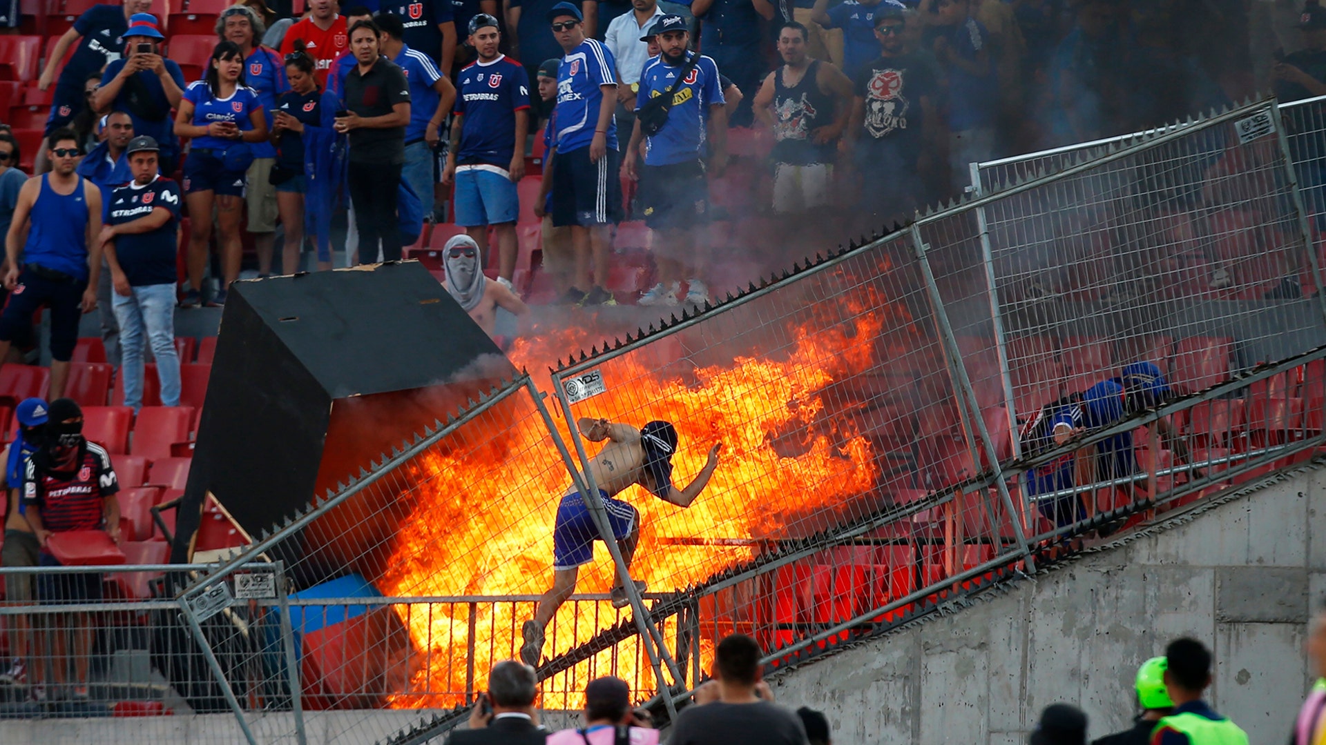 A small group of anti-government protesters set a section of the stadium on fire during the Copa Libertadores soccer game between Universidad de Chile and Brazil's SC Internacional, in Santiago, Chile, Feb. 4, 2020.