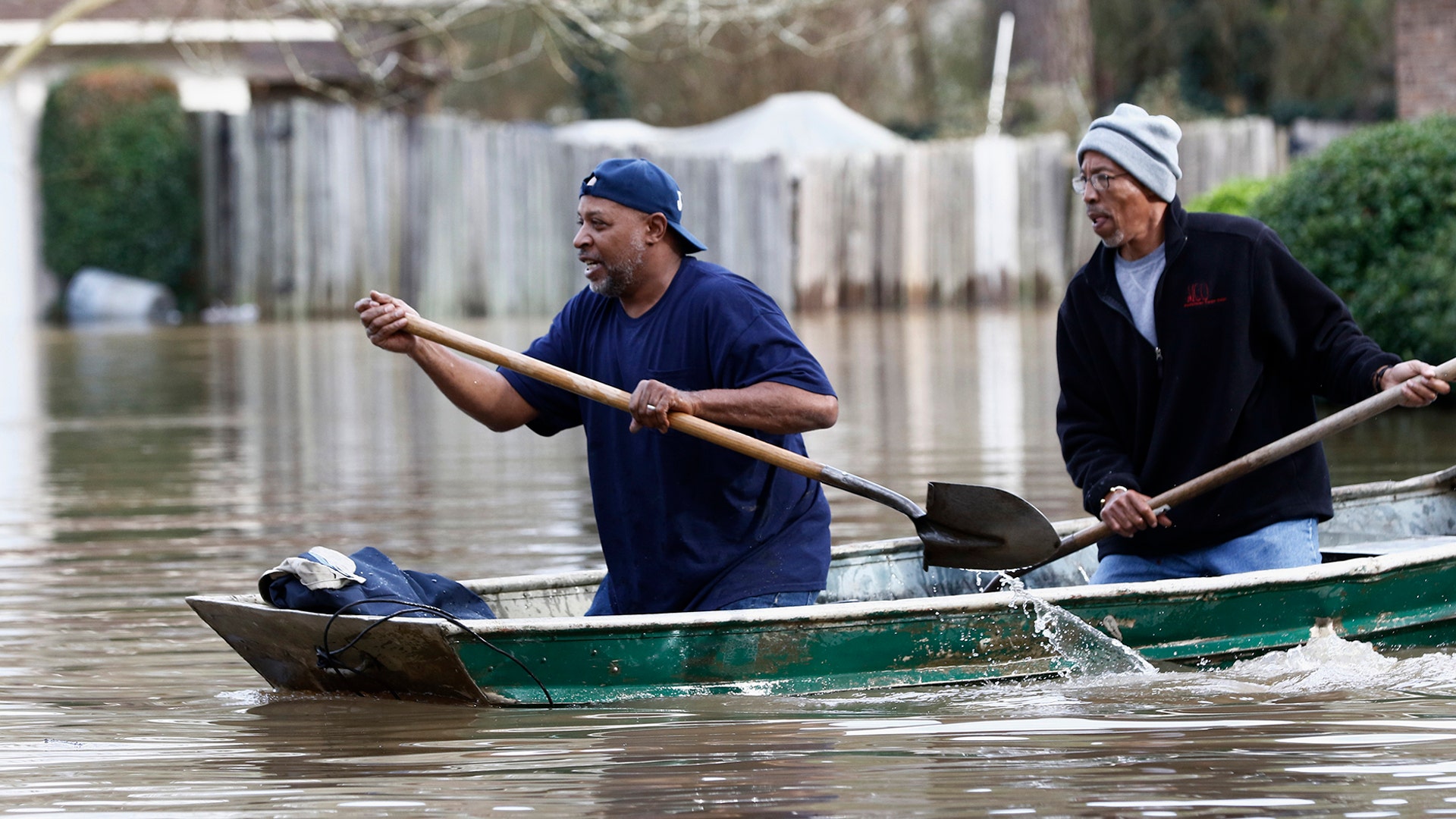 Jackson, Miss., homeowners use shovels as oars to work their way through Pearl River floodwater in this Jackson, Miss., neighborhood Sunday.