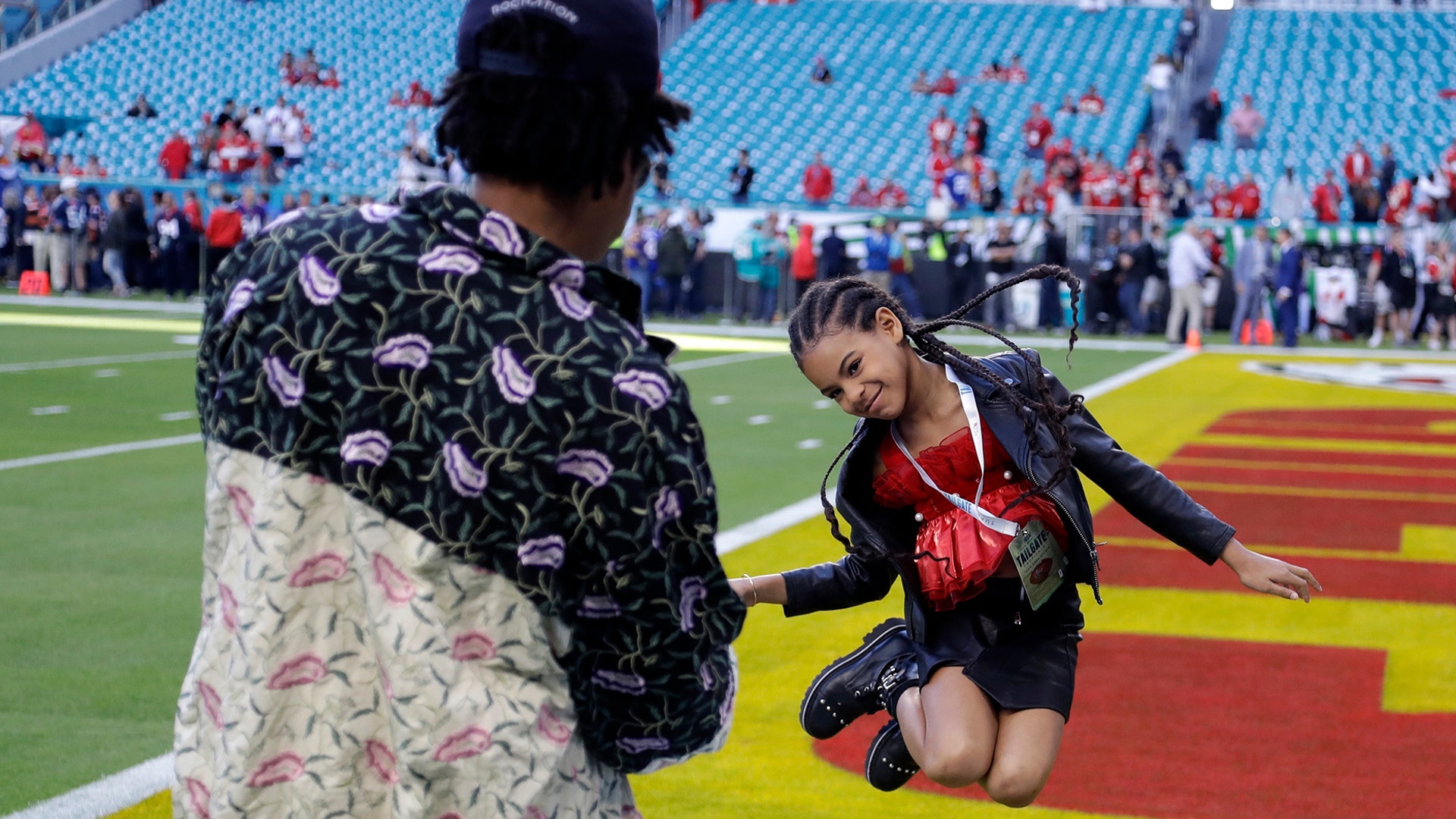 Entertainer Jay-Z photographs his daughter Blue Ivy Carter as she leaps on the field before the Super Bowl in Miami, Feb. 2, 2020.