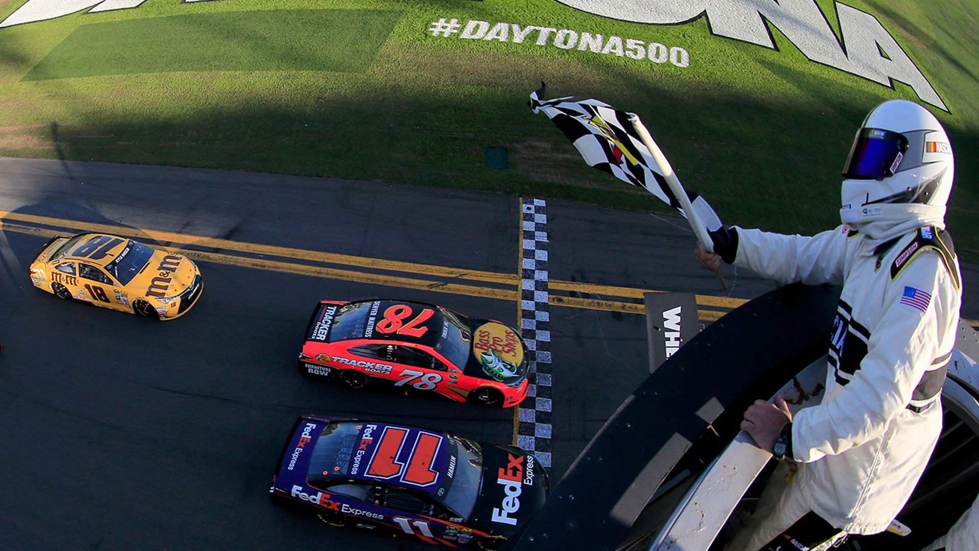 Denny Hamlin, driver of the #11 FedEx Express Toyota, takes the checkered flag ahead of Martin Truex Jr., driver of the #78 Bass Pro Shops/Tracker Boats Toyota, to win the NASCAR Sprint Cup Series DAYTONA 500 at Florida's Daytona International Speedway on Feb. 21, 2016.