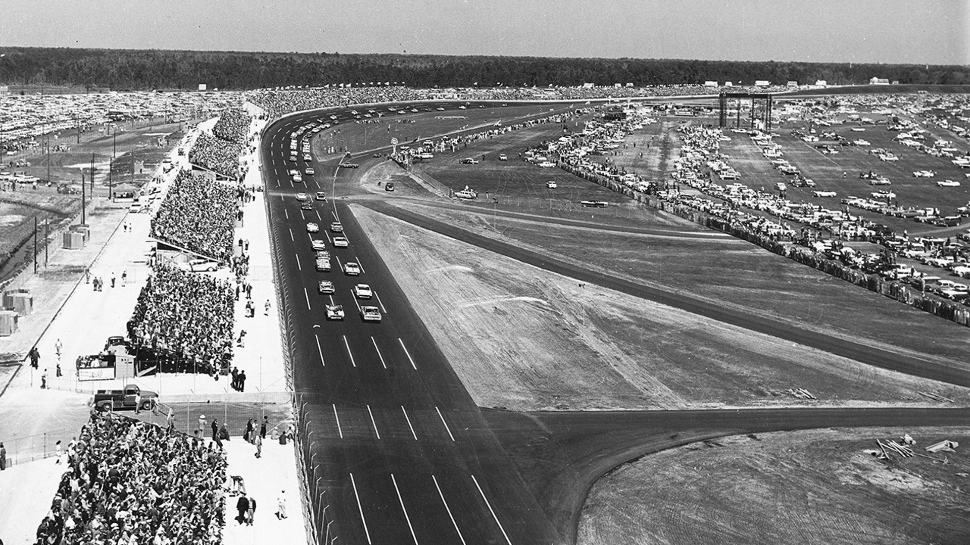 The green flag starts the first Daytona 500 in 1959. Lee Petty, driving an Oldsmobile, beat Johnny Beauchamp's Ford Thunderbird by inches to take the victory. Both hardtops and convertibles ran in the race, an official "sweepstakes" race for both NASCAR Grand National (now Cup) and Convertible Divisions.