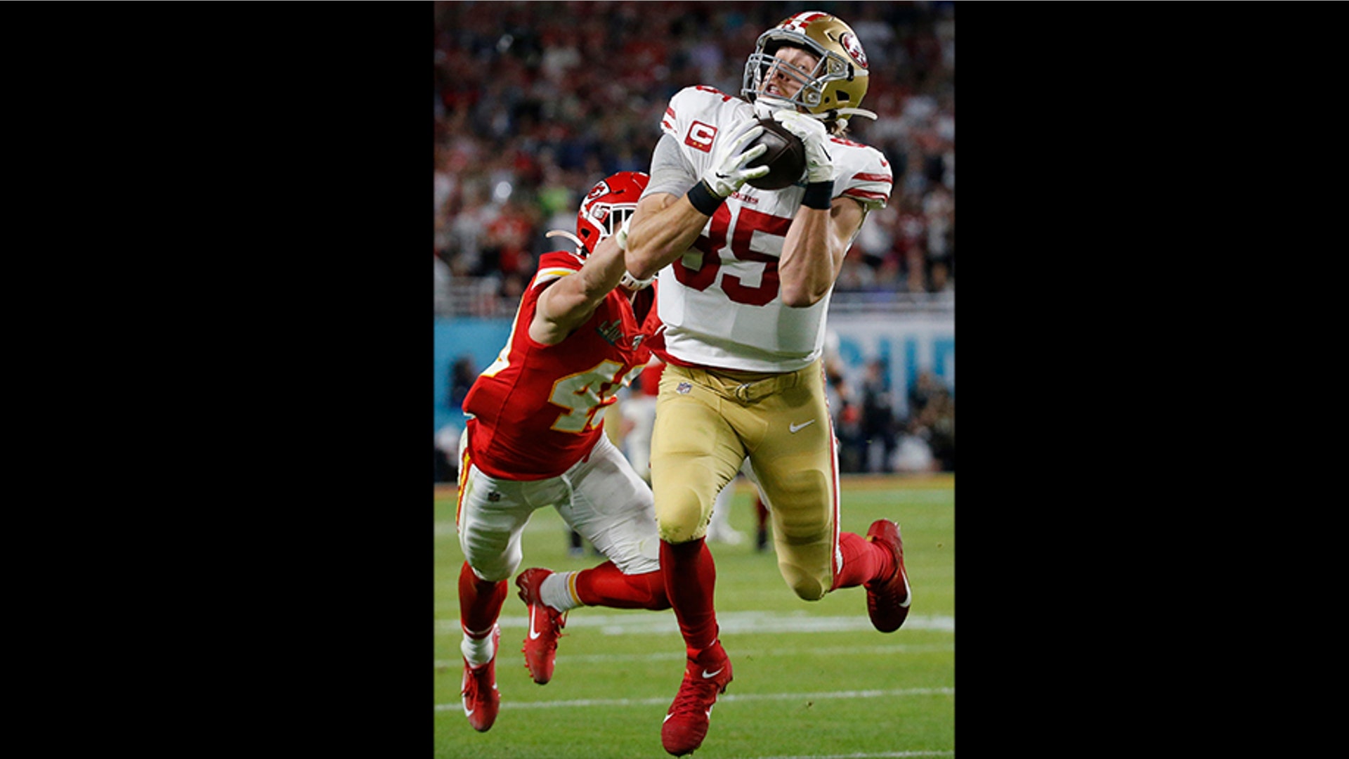 San Francisco 49ers' George Kittle (85) catches a pass in front of Kansas City Chiefs' Daniel Sorensen during the first half. The play was called back on a penalty by Kittle.