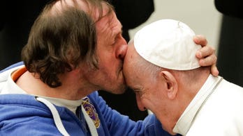 Pope Francis receives kiss on forehead from front-row admirer