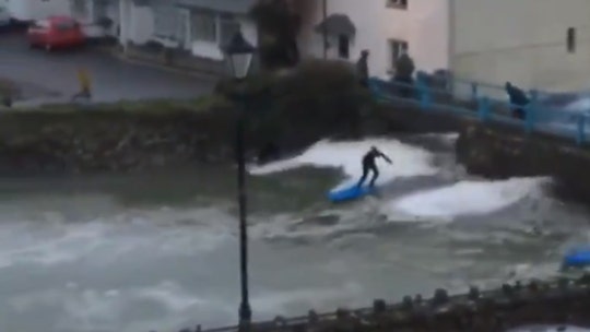 Surfers catch large waves from major Europe storm under bridge in England