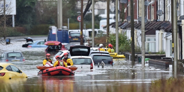 Um membro do público é resgatado após inundações em Nantgarw, País de Gales, domingo, 16 de fevereiro de 2020.