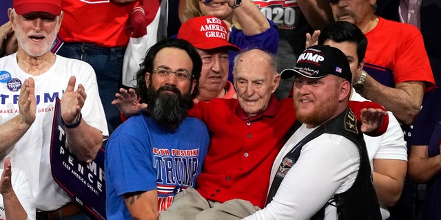 Trump supporters hold up Ervin Julian, a 100-year-old World War II veteran, during a rally supporting President Donald Trump on Wednesday, Feb. 19, 2020 in Phoenix. (Associated Press)