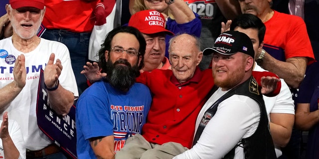 Trump supporters hold up Ervin Julian, a 100-year-old World War II veteran, during a rally supporting President Donald Trump on Wednesday, Feb. 19, 2020 in Phoenix. (AP Photo/Rick Scuteri)