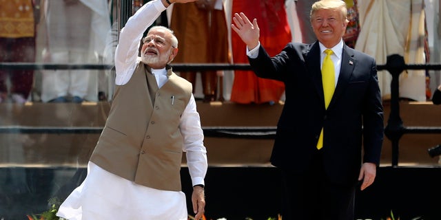 U.S. President Donald Trump and Indian Prime Minister Narendra Modi wave to the crowd at Sardar Patel Stadium in Ahmedabad, India, Monday, Feb. 24, 2020. (AP Photo/Aijaz Rahi)