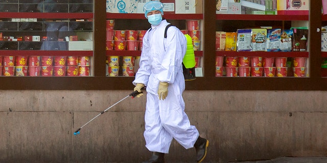 A worker sprays disinfectant outside the Beijing Railway Station in China on Saturday. (AP)