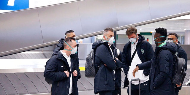 Members of Bulgarian soccer team Ludogorets are seen wearing protective face masks at Malpensa airport in Milan, Italy, ahead of their Europa League soccer match on Feb. 27.