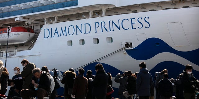 Media gather outside the quarantined Diamond Princess cruise ship in Yokohama, near Tokyo, Tuesday, Feb. 11, 2020. Japan's Health Minister Katsunobu Kato said the government was considering testing everyone remaining on board and crew on the Diamond Princess, which would require them to remain aboard until results were available. (AP Photo/Jae C. Hong)