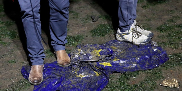 Brexit supporters trample on a European Union flag during a rally in London, Friday, Jan. 31, 2020. Britain officially leaves the European Union on Friday after a debilitating political period that has bitterly divided the nation since the 2016 Brexit referendum. (AP Photo/Frank Augstein)