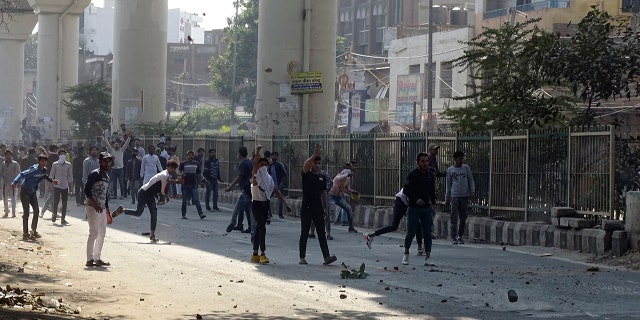 A group of protestors clash with another group in New Delhi, India, Monday, Feb. 24, 2020. Indian paramilitary troops used tear gas and smoke grenades to disperse a crowd of clashing protesters in New Delhi on Monday as violence broke out over a new citizenship law just ahead of U.S. President Donald Trump’s visit to the city. (AP Photo/Dinesh Joshi)