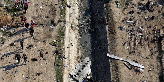 Rescue workers search the scene where a Ukrainian plane crashed in Shahedshahr, southwest of Tehran, Iran on Jan. 8.The downing of a Ukrainian jetliner near Tehran highlights the limits of the civilian arm of Ir an's government against the absolute power of the Shiite theocracy and the paramilitary forces beneath it. (AP Photo/Ebrahim Noroozi, File)