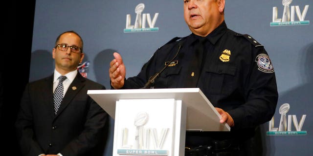 Christopher D. Maston, U.S. Customs and Border Protection, Miami International Airport Port Director, right, speaks as Steve K. Francis, Global Trade Investigations Division Assistant Director and National Intellectual Property Rights Coordination Center Director looks on, during news conference about seized counterfeit merchandise and tickets related to the NFL Super Bowl 54 football game, Thursday, Jan. 30, 2020, in Miami Beach, Fla. (AP Photo/Chris Carlson)