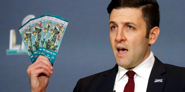 Michael Buchwald, NFL Senior Counsel, holds up authentic tickets for the NFL Super Bowl 54 football game during a news conference about seizures of counterfeit game-related merchandise and tickets, Thursday, Jan. 30, 2020, in Miami Beach, Fla. (AP Photo/Chris Carlson)