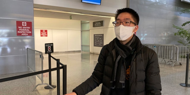 In this Wednesday, Jan. 29 photo, traveler Bill Chen stands outside of customs at San Francisco International Airport after arriving on a flight from Shanghai, where he was conducting business and visiting family over the Lunar New Year holiday. (AP Photo/Terry Chea)