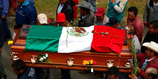 Mourners carry the flag-draped coffin of community activist Homero Gomez Gonzalez as the funeral procession makes its way from the church to a hillside cemetery, in Ocampo, Michoacan state, Mexico, Friday, Jan. 31, 2020. Hundreds of farmers and agricultural workers attended the funeral Friday, and the homage to the anti-logging activist was like a tribute to the monarch butterfly he so staunchly defended. (AP Photo/Rebecca Blackwell)