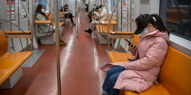People wearing face masks ride a mostly empty subway train during the morning rush hour in Beijing, Monday, Feb. 3, 2020.  (AP Photo/Mark Schiefelbein)